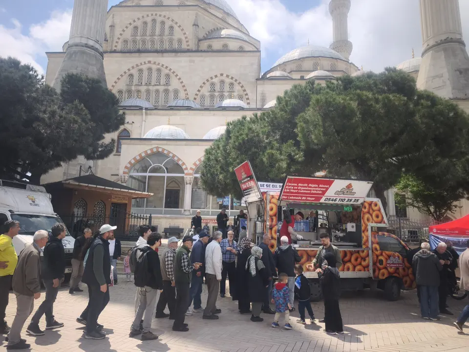 Cami önünde sıcak lokma alan kalabalık ve Hayrat Lokması aracı
